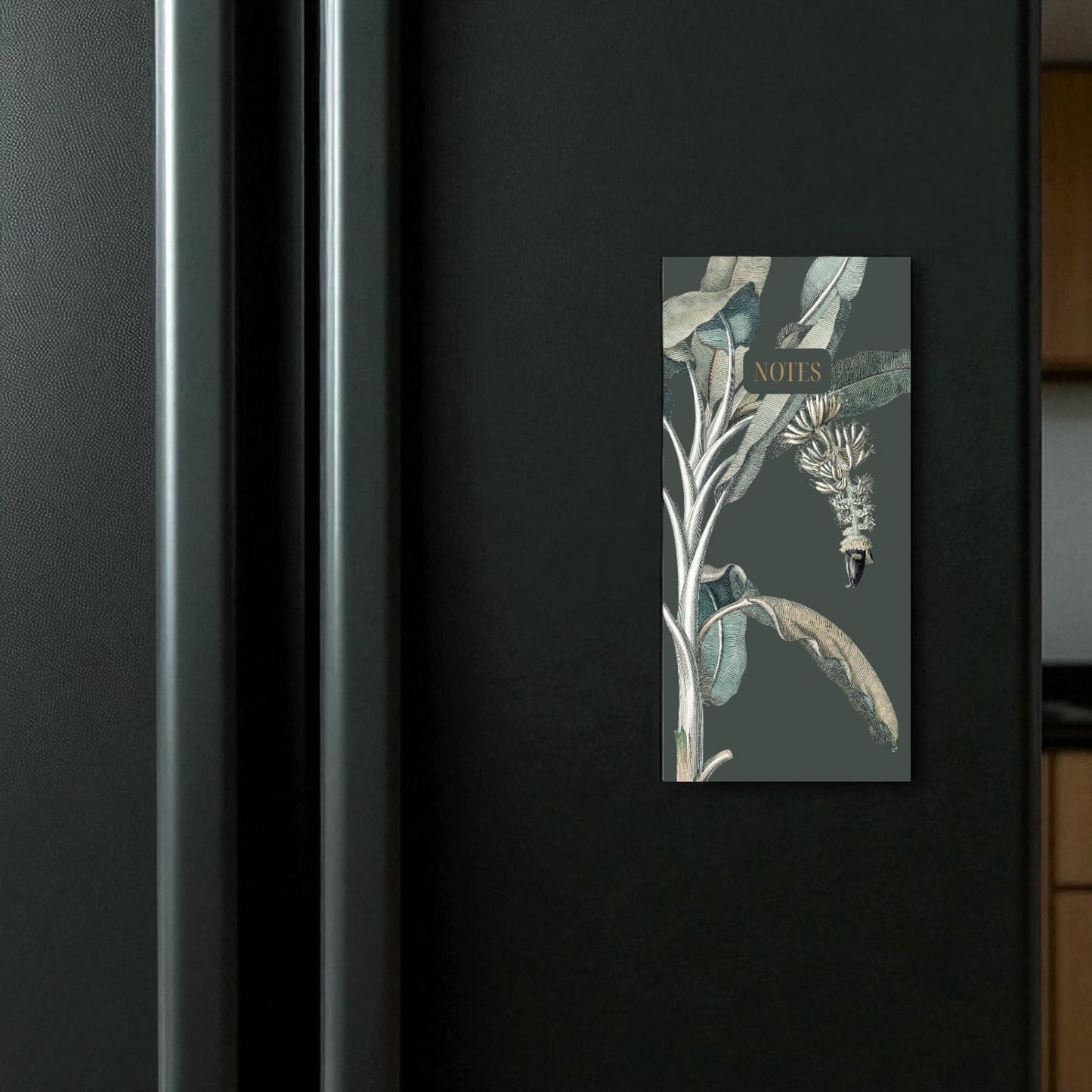 Decorative magnet with nature-themed design on a black appliance
