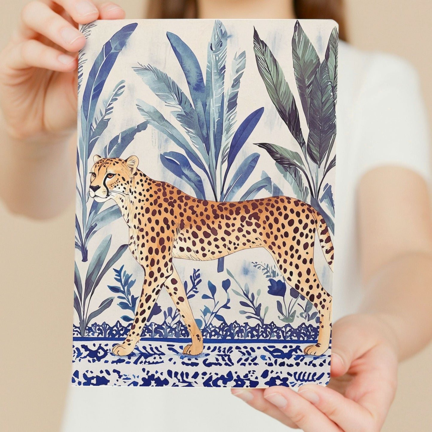 Notebook with a cheetah and leaf design held by hands