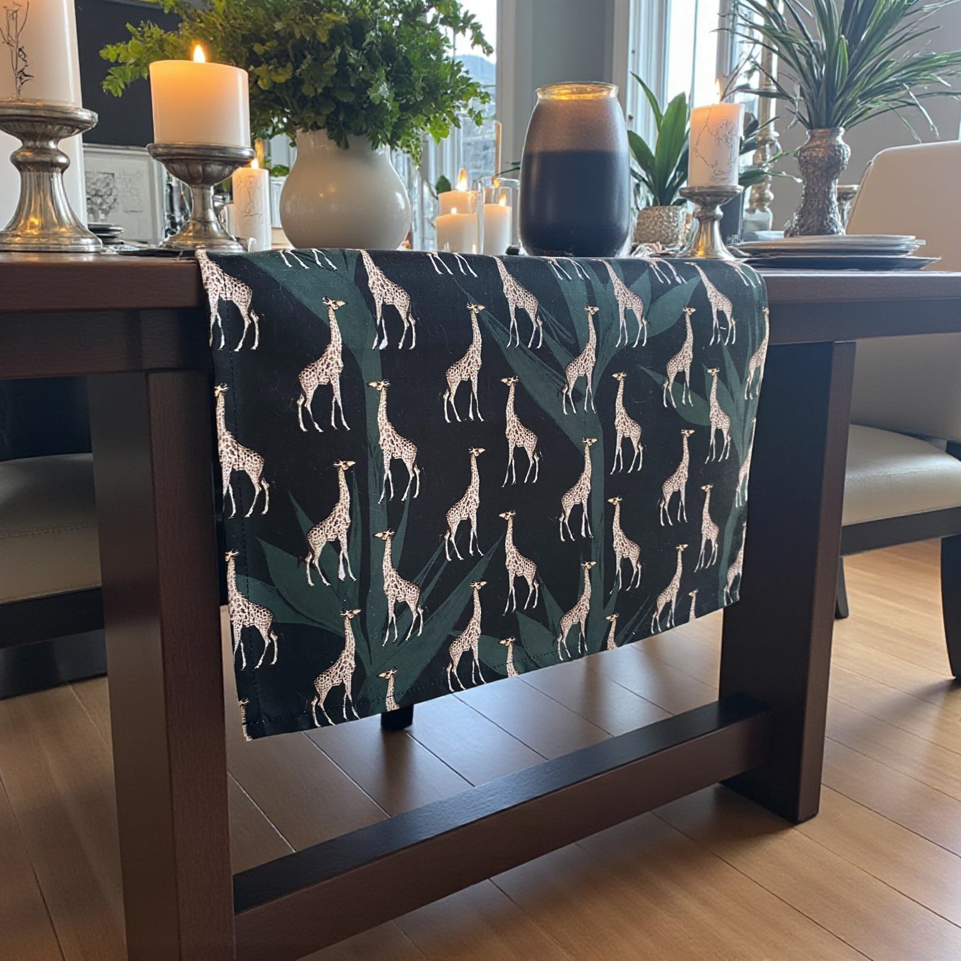 Table runner with a giraffe patterned tablecloth and candles in a well-lit room.