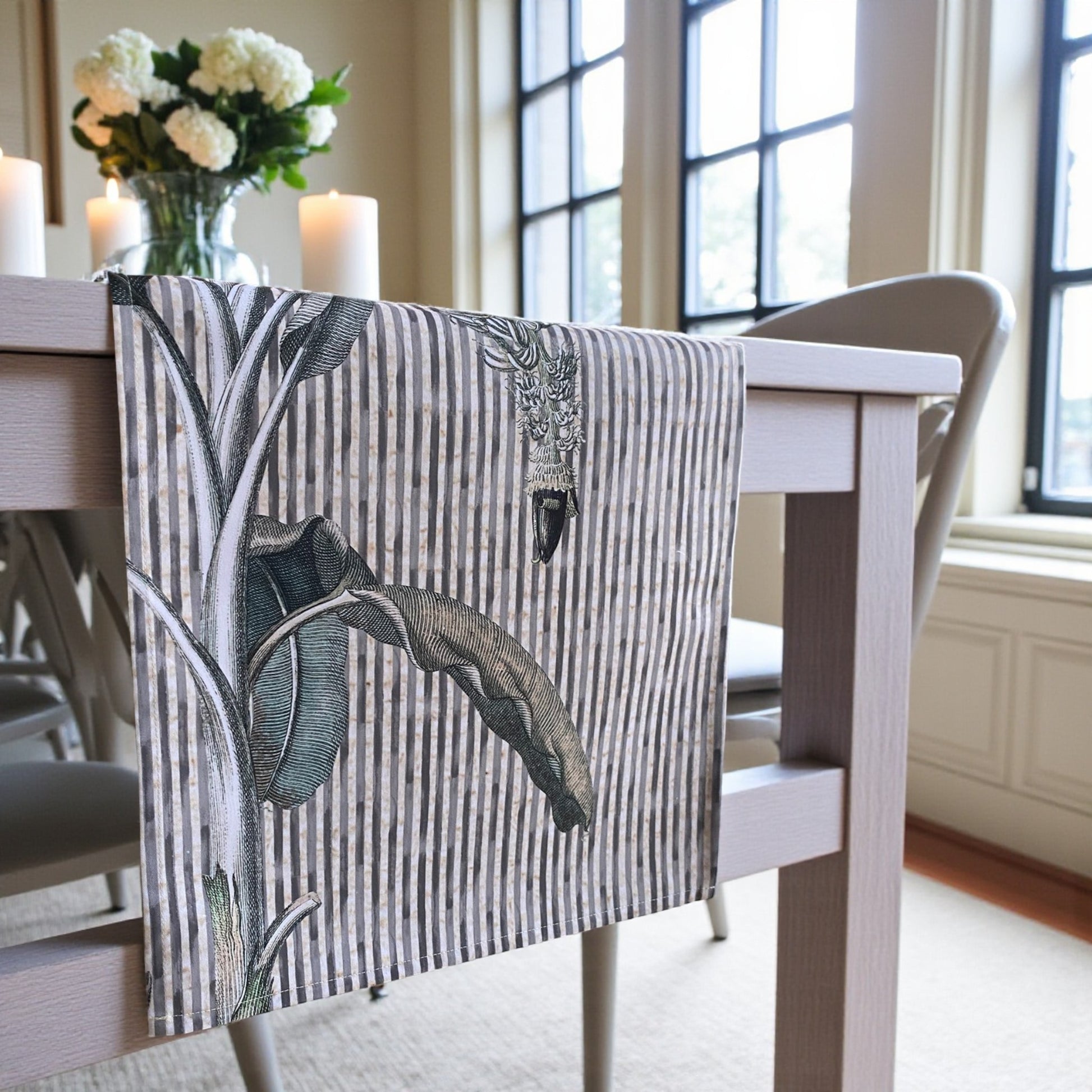 Dining table with a decorative Table  runner featuring leaf patterns in a home setting