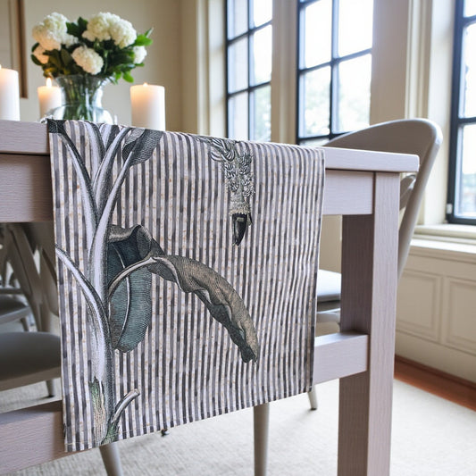 Dining table with a decorative Table  runner featuring leaf patterns in a home setting