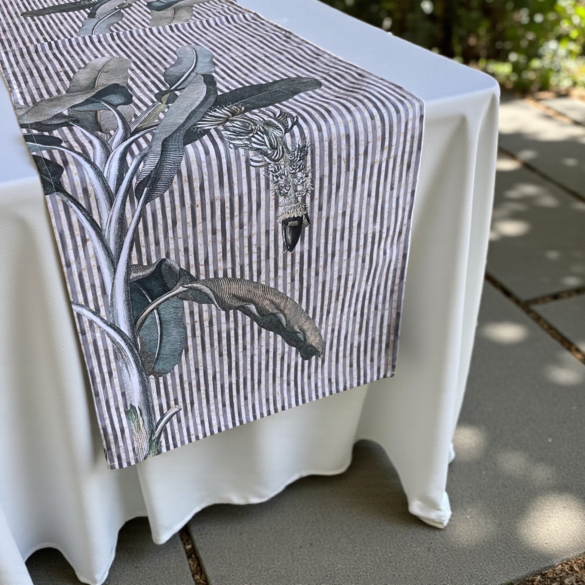 Table runner  with nature-themed design on a white table outdoors